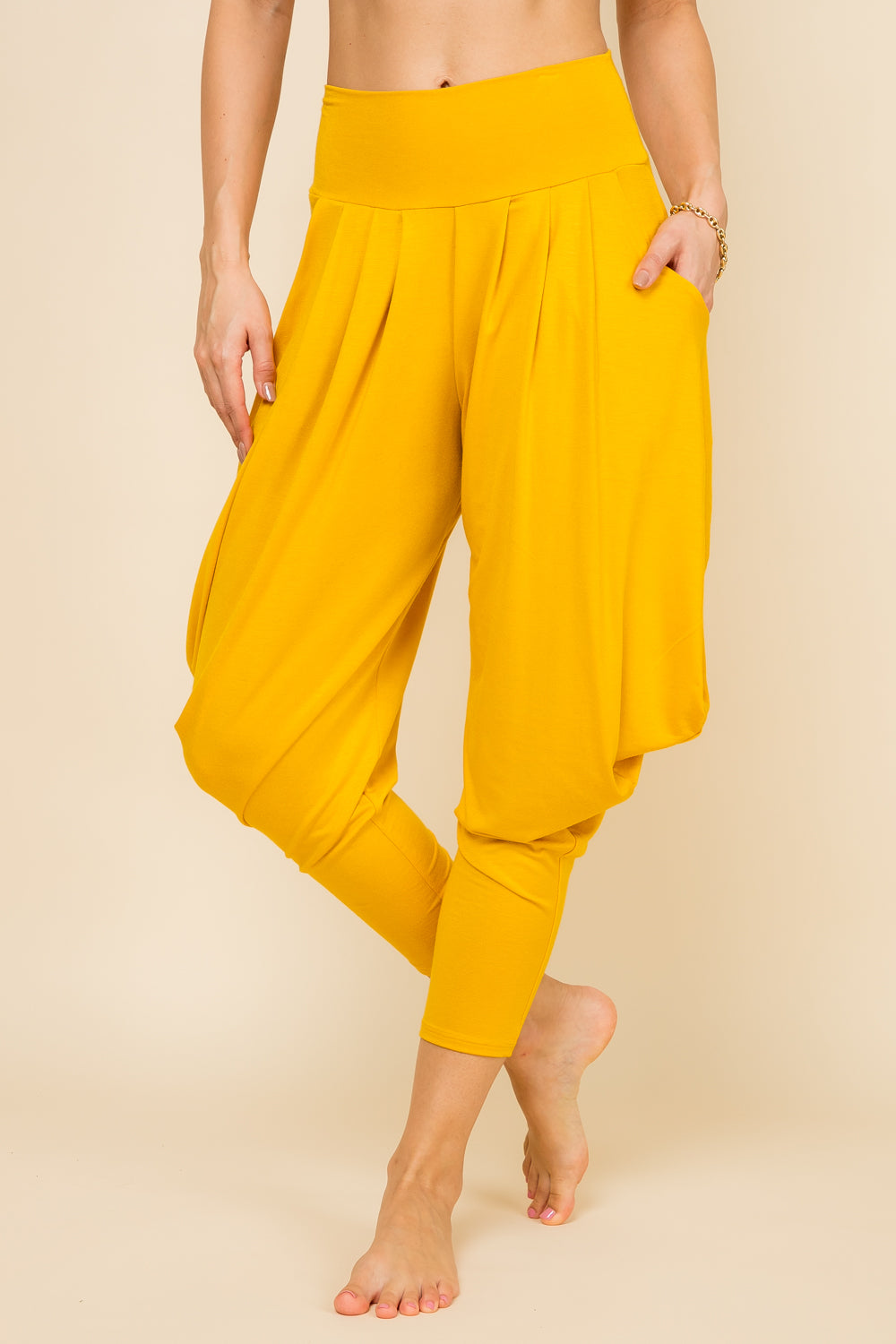 Front view of woman wearing mustard Kooniez harem pants with pockets – made in LA