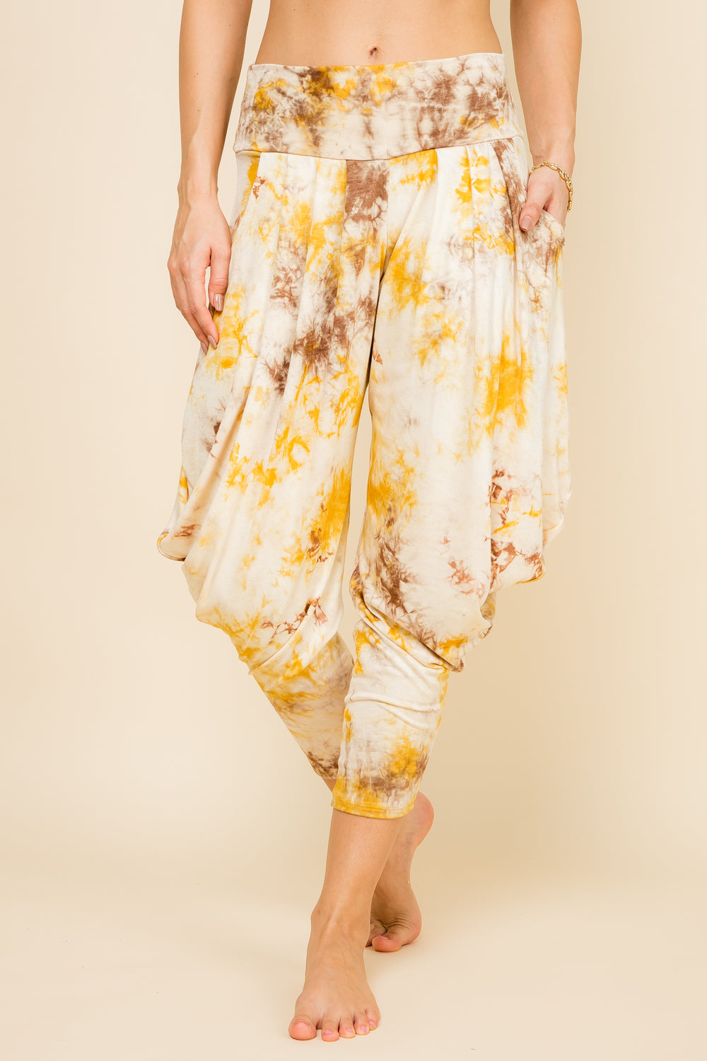 Front view of woman wearing mustard tie-dye Kooniez harem pants with pockets – made in LA